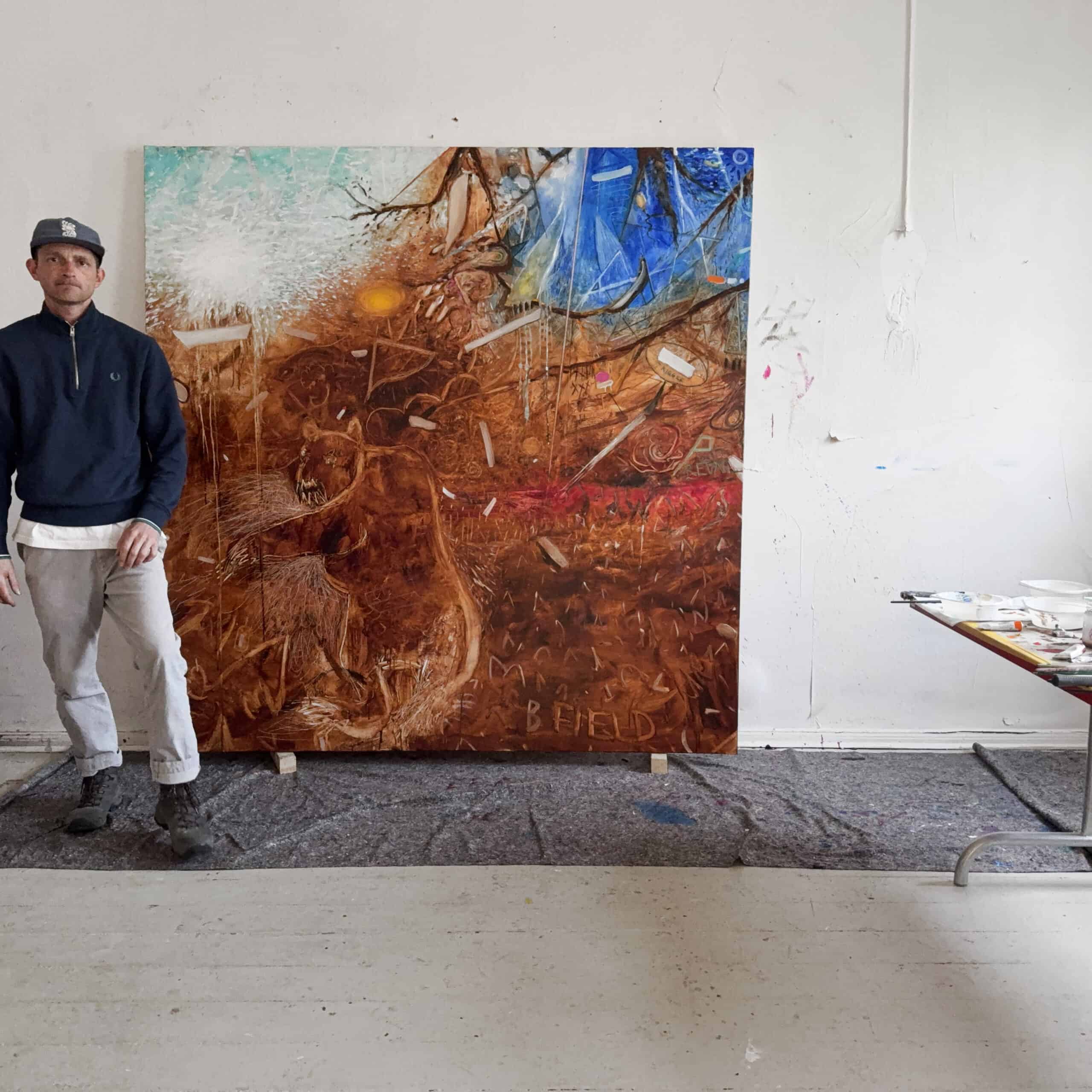 A portrait of Nikolaus Kriese standing next to his large, abstract contemporary painting in his studio, showcasing his artistic style and international shipping services.
