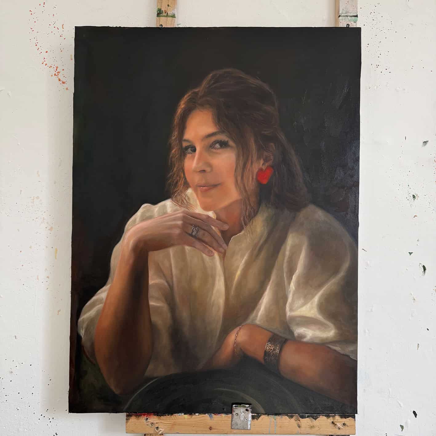 Portrait of a woman with red heart-shaped earring, painted by Nikolaus Kriese, showcasing detailed realism and vibrant colors, available for international commission.
